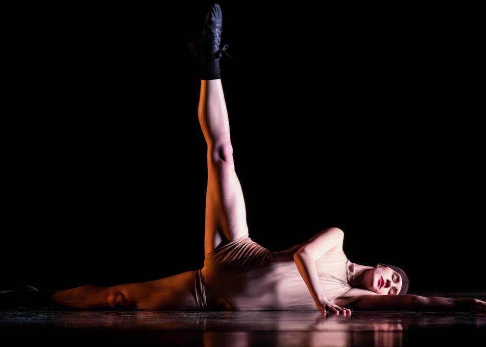 A dancer lays on her side with her right leg extended straight up in "Fearing the Unknown"